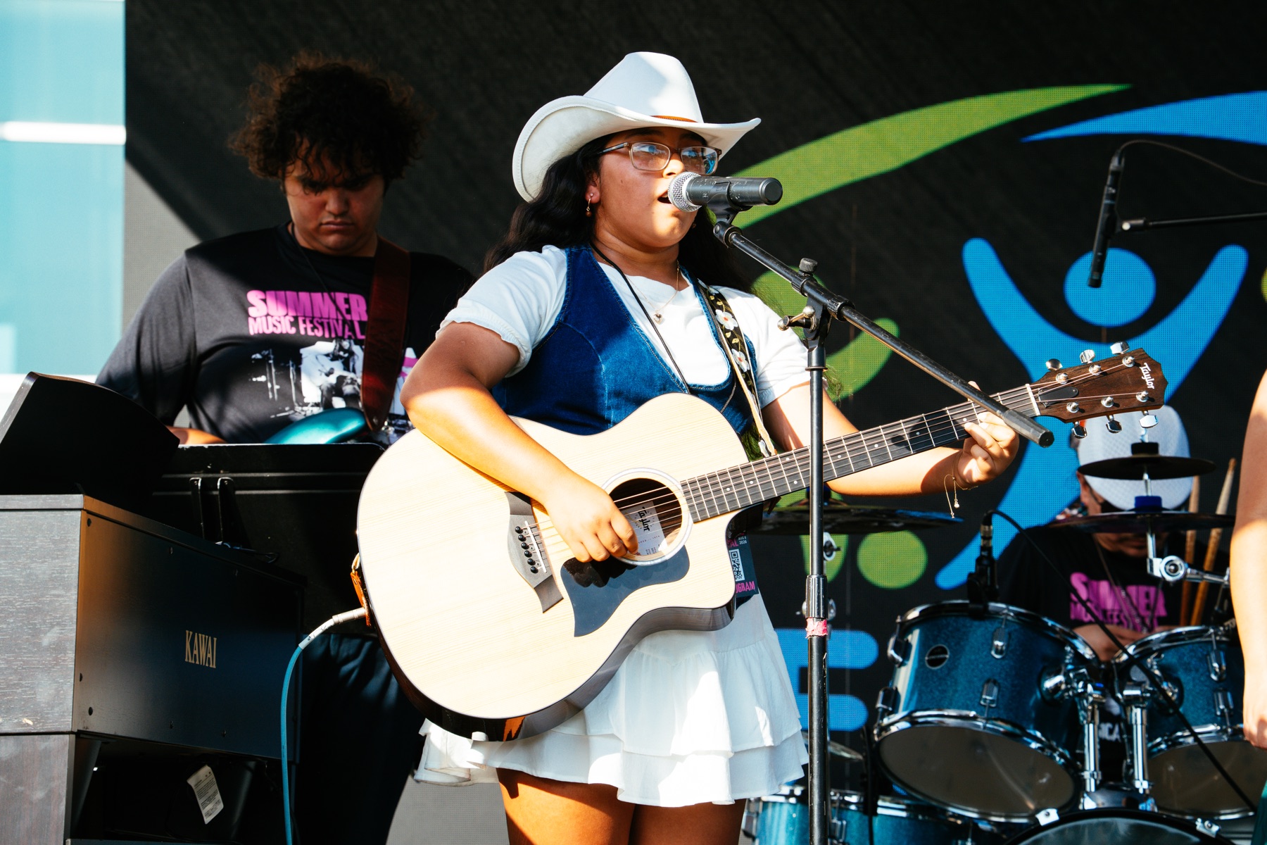 Olivia Faith Reyes singing and playing acoustic guitar